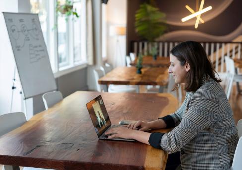 Woman with laptop participating in virtual meeting 