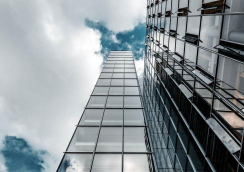 Glass office building against backdrop of sky 